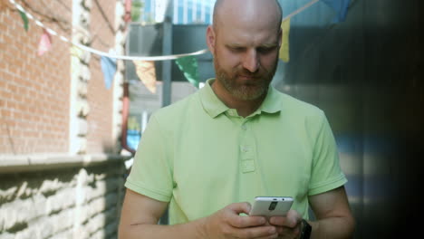 man using smartphone in city alley