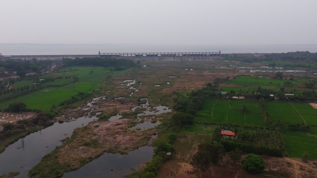 Diga di Tungabhadra con campi coltivati, fiume e cielo a Munirabad, Karnataka, India. Di giorno, ripresa a ritroso, ripresa con drone, 4K.