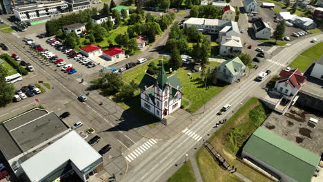 Iglesia-De-Madera-Islandesa-En-Husavik,-Famoso-Pueblo-Pesquero,-Toma-Aérea-En-Un-Día-Soleado