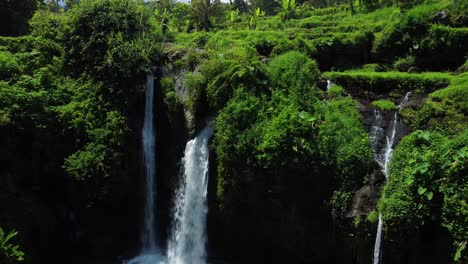 Vista-Aérea-De-La-Cascada-Kembar-Arum-Que-Fluye-Y-Cae-En-Un-Paisaje-Tropical-En-Indonesia,-Asia