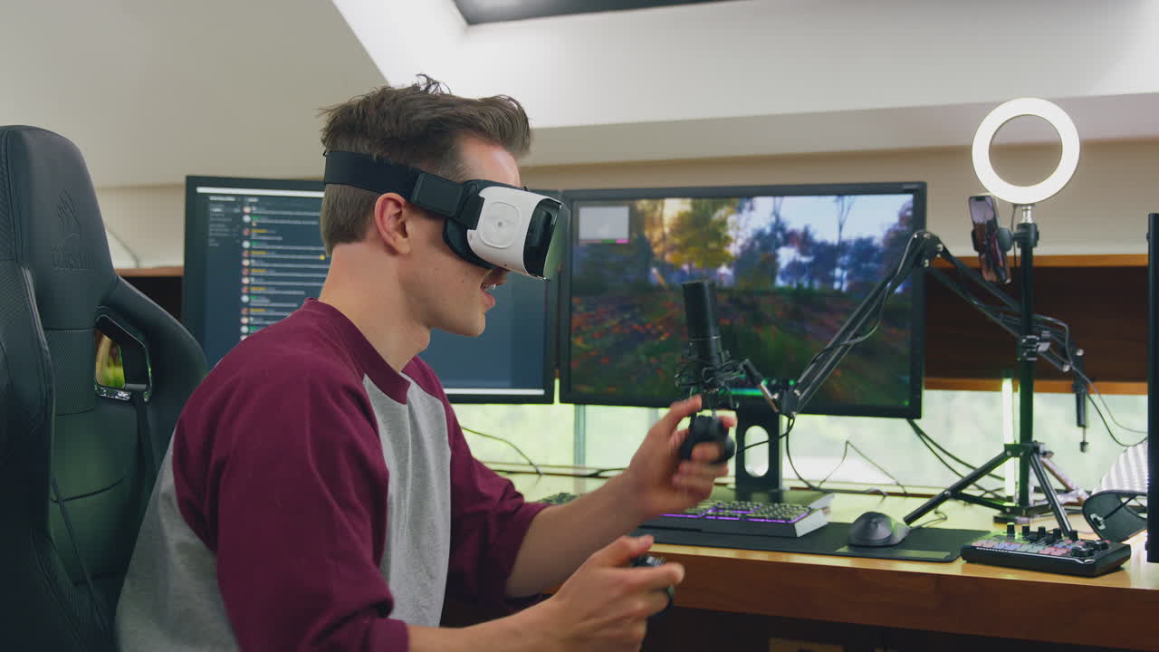 Man Wearing VR Or AR Headset Gaming At Home Sitting At Desk Live Streaming Shooting Game