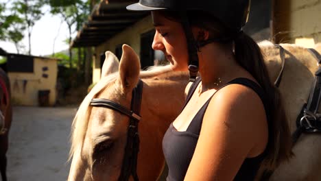 female horse rider pauses at the stable door awaiting instruction to head to the arena on a sunny morning