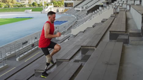 caucasian disabled male athlete with prosthetic leg training, running up stairs