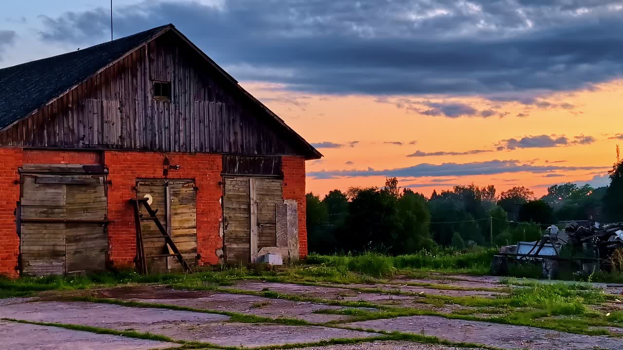 Old Wooden and Brick Farm Barn Standing Quiet Under Dramatic Sunset Sky