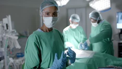 portrait of diverse surgeons with face masks during surgery in operating room in slow motion