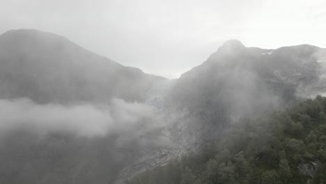 flying through dense fog and reveal majestic glacier, high altitude drone view