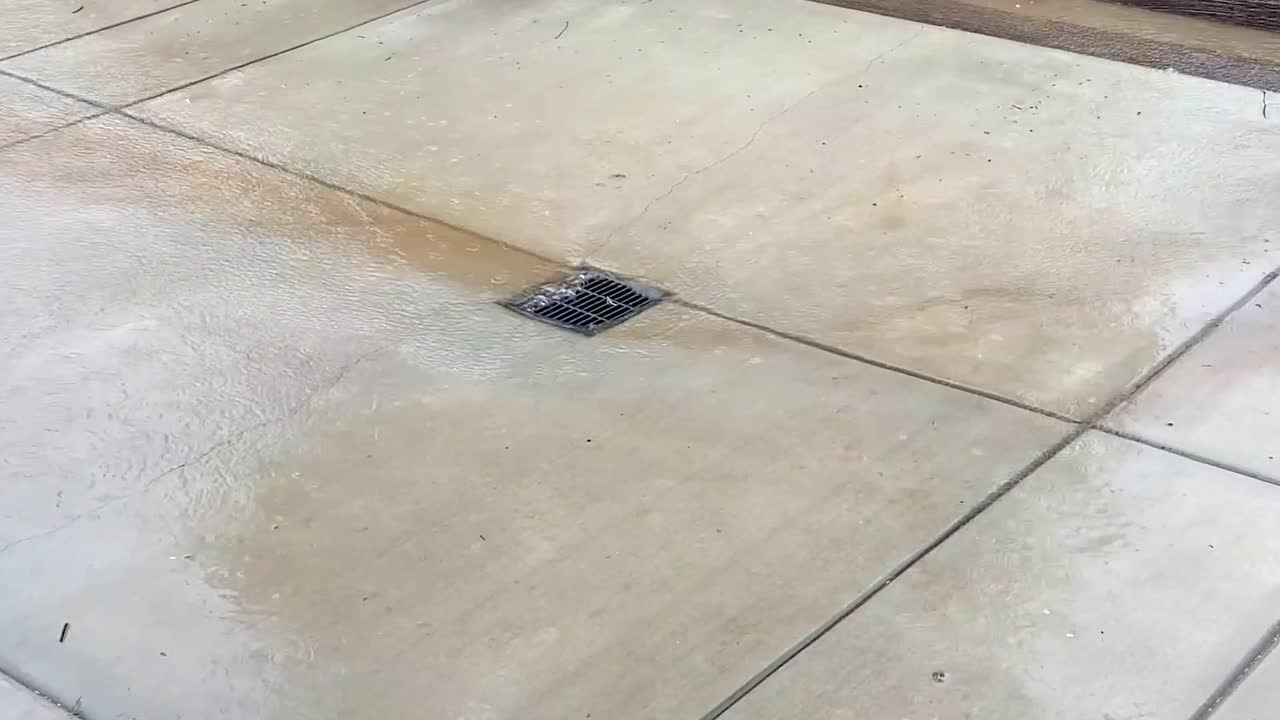 agua de inundación de las lluvias en california vertiendo rápido y pesado en el canalón de desagüe de un patio trasero
