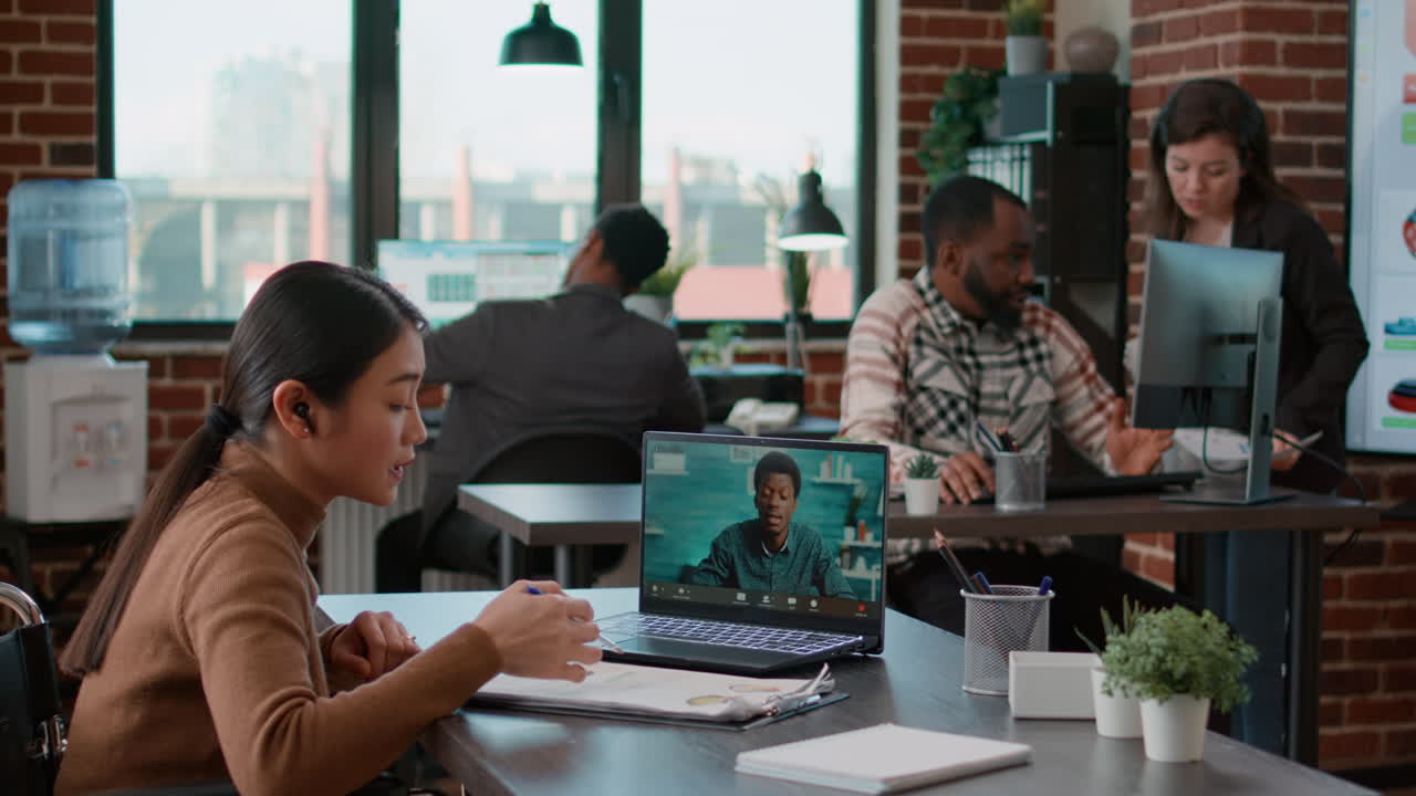 Asian woman in wheelchair meeting with man on videocall