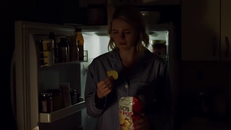 woman eating chips at night