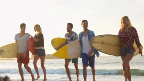 Grupo-De-Amigos-Sosteniendo-Tabla-De-Surf