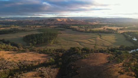 aerial footage across the hills lit by early morning light near the goulburn river in victoria australia