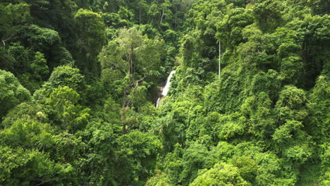 aerial pan left of huay to waterfall among lush vegetation on sunny day, krabi