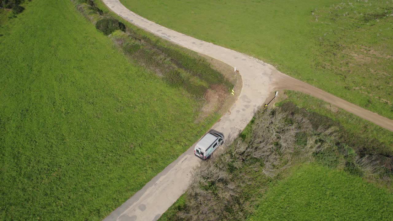 Inquadratura aerea statica di un camper che percorre una curva su una strada sterrata nel sud della Spagna
