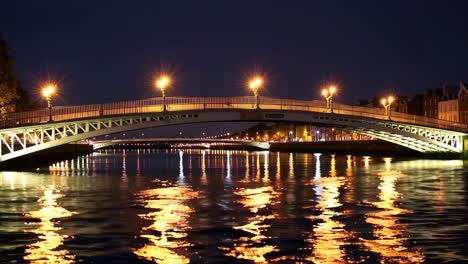 puente iluminado que se refleja en el agua por la noche