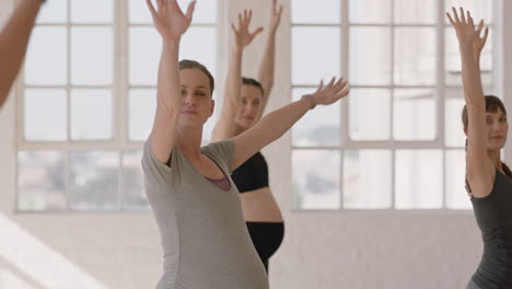 young pregnant caucasian woman in yoga class practicing warrior pose enjoying healthy lifestyle group exercising in fitness studio at sunrise