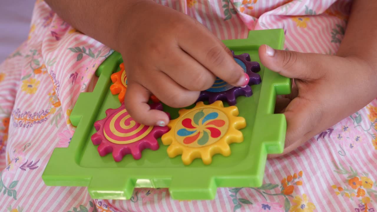 niño jugando con un rompecabezas de engranajes coloridos