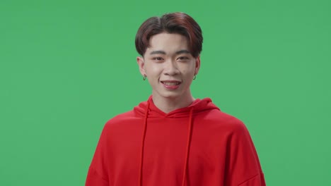 angry asian transgender male scolding while standing on green screen in the studio
