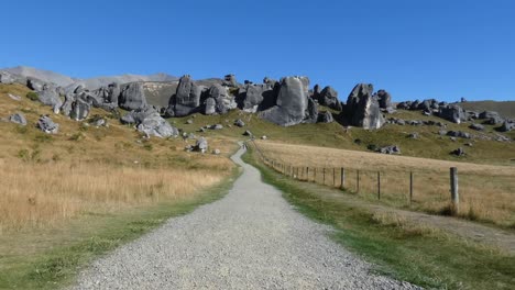 Walkway-to-incredible-limestone-rock-formations-at-Castle-Hill-in-summertime---Castle-Hill-Conservation-Area,-New-Zealand