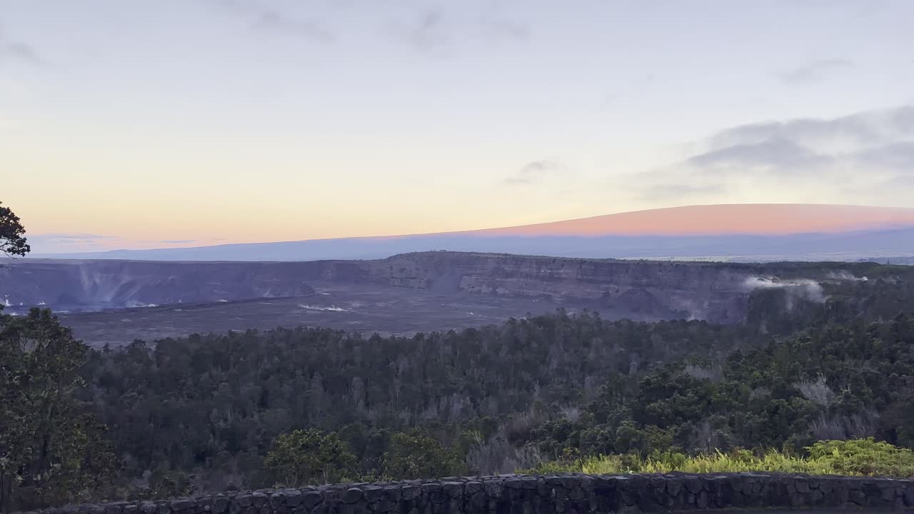 Cinematic wide panning shot from Mauna Loa to Kilauea from Volcano House at sunrise in Hawai'i Volcanoes National Park