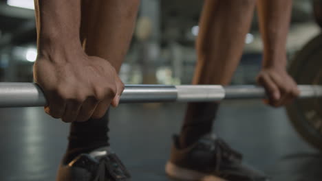 Close-up-view-of-man's-hands-holding-a-barbell