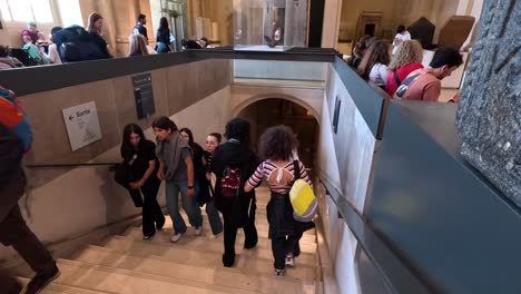 people walking down stairs at the louvre