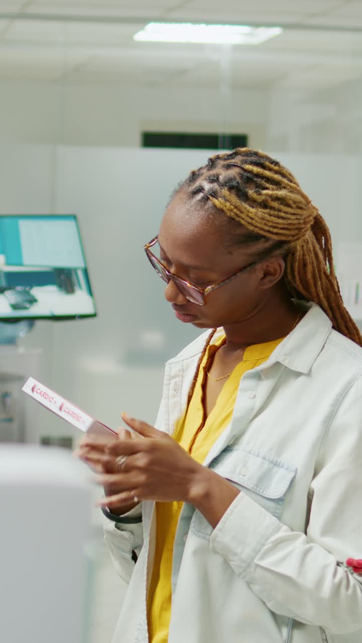 Vertical video: Young woman reading leaflet from box of pharmaceutics