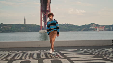 Millennial-hipster-riding-skate-at-river-background.-Man-practicing-longboard