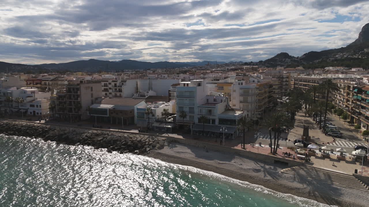 Scenic aerial pans over urban shoreline and marina district with curved waterfront road