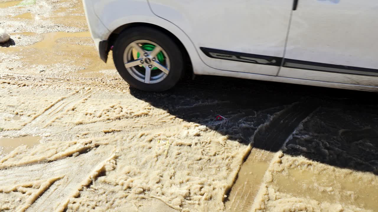 coche circulando por aguanieve fangosa y helada en una carretera invernal