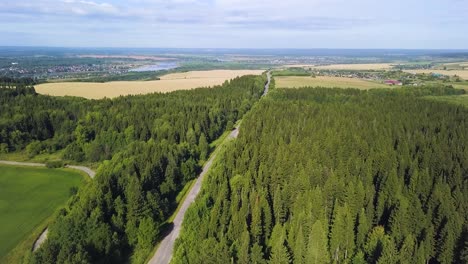 aerial view of a winding road through a forest and countryside