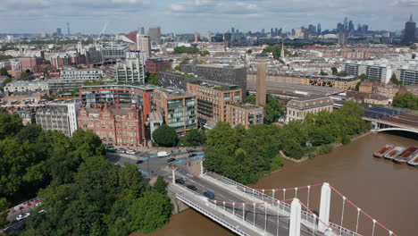 Aerial-view-of-traffic-on-road-intersection-near-Chelsea-bridge.-Mixture-of-old-and-modern-residential-buildings.-Downtown-skyscrapers-in-background.-London,-UK