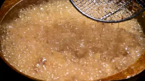 olla de aceite caliente burbujeante freír mariscos de calamares o calamares al sol al aire libre