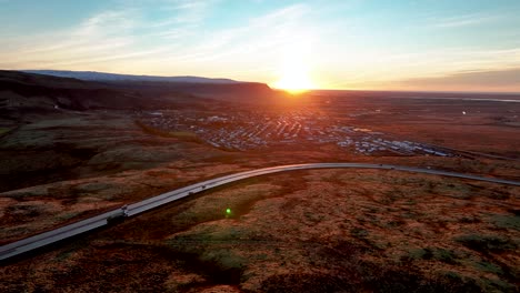 Vista-Aérea-De-La-Ciudad-De-Hveragerdi-Y-La-Carretera-Número-Uno-Durante-El-Amanecer-En-El-Sur-De-Islandia---Disparo-De-Drones