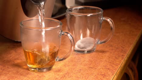 Gießen-Sie-Kochend-Heißes-Wasser-über-Teebeutel-In-Durchsichtige-Teetassen