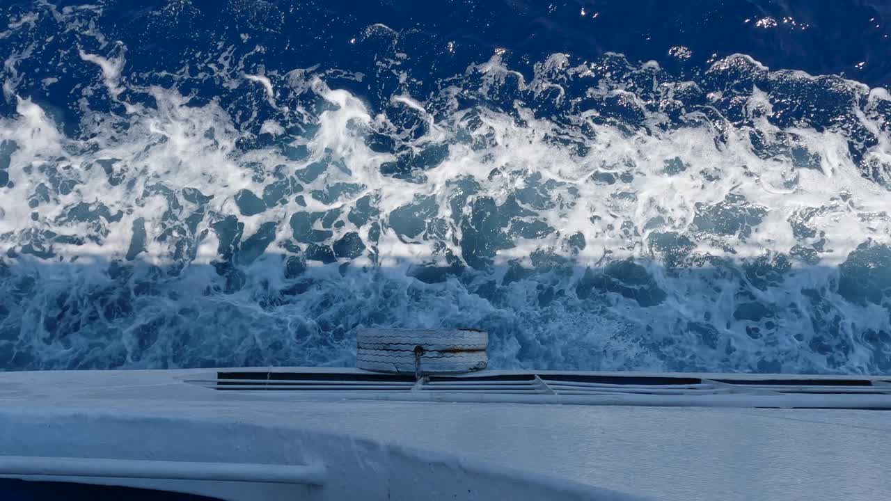 정오에 잔잔한 바다의 물을 항해하는 배의 측면에서 보기