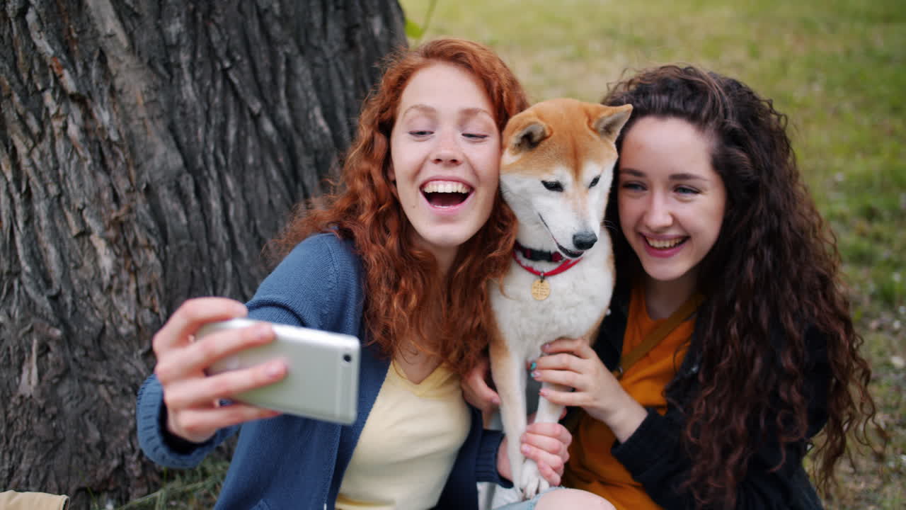 Friends taking a selfie with a Shiba Inu in a park
