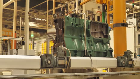assembly line workers in engines heavy duty truck car factory assembling parts of a vehicle, with robotic arms aiding production.
