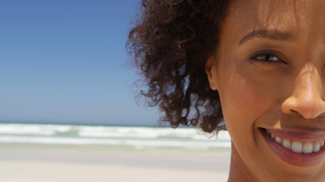 Primo piano di donna che sorride in spiaggia in una giornata di sole 4k