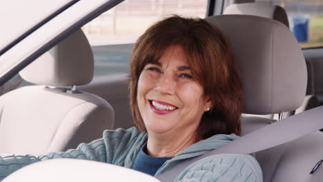 senior woman in car driving seat looking out of side window