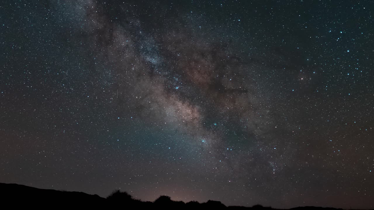 사막 지평선 위의 하늘을 가로지르는 화려한 색상의 은하수 추적 - 시간 경과