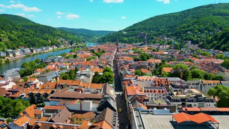 4k aerial drone video of historic homes, shops, and churches along the neckar river in downtown heidelberg, germany