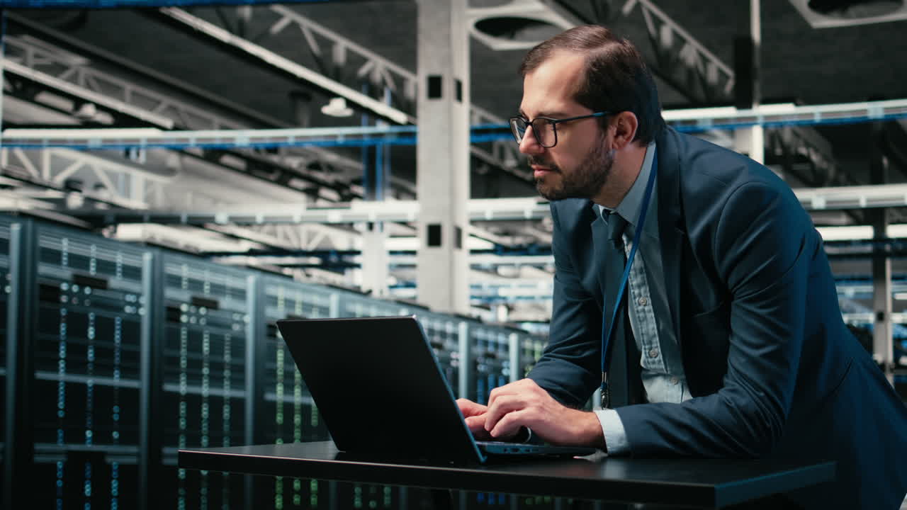 Businessman Working on Laptop in Modern Data Center