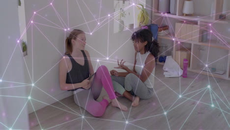 animation of glowing network over happy diverse teenage girls talking at yoga class