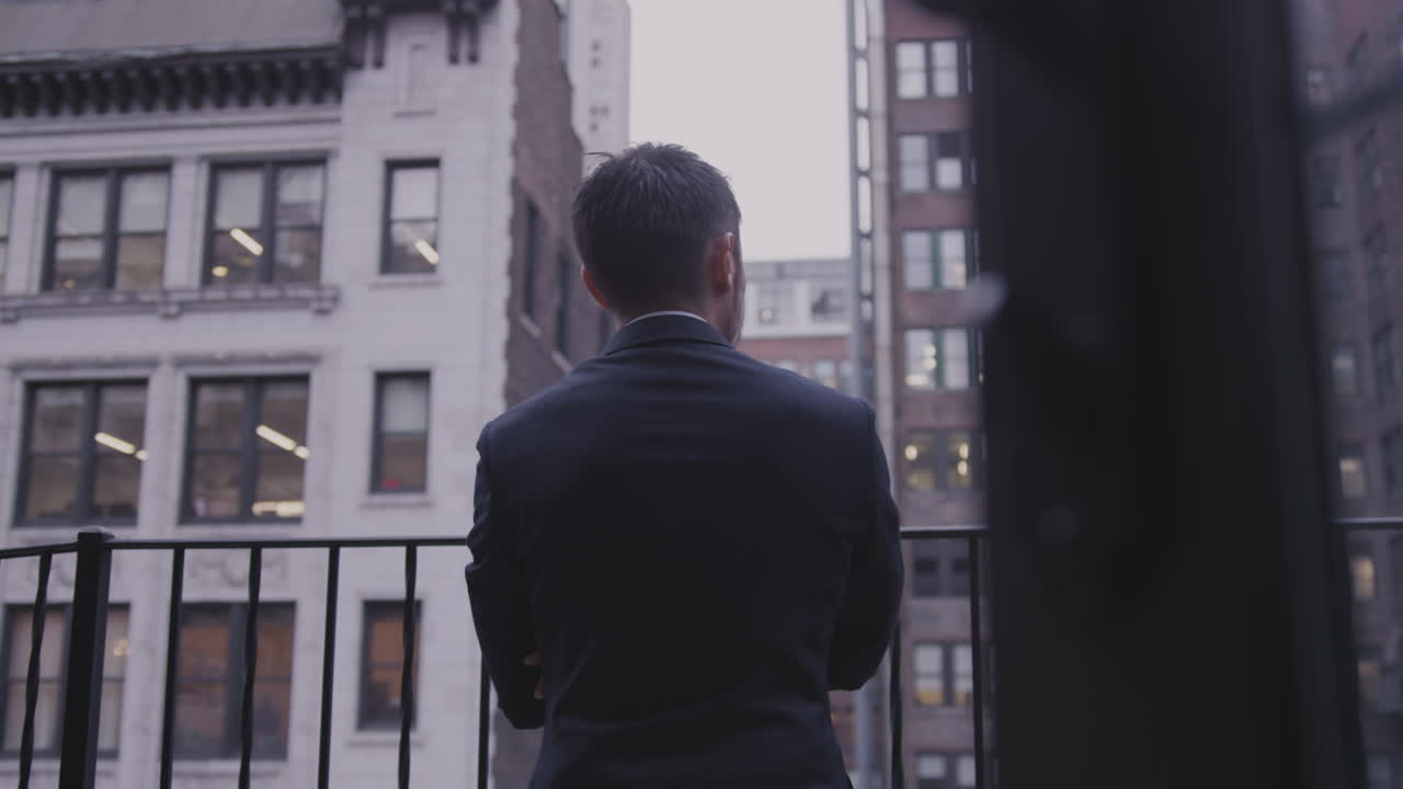 A man stand son the balcony on a cloudy day