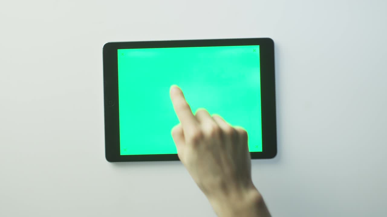 las manos están poniendo la tableta pc con pantalla verde en la mesa blanca y comenzando a usarla. genial para el uso de maquetas. disparado en cámara de cine roja