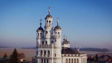 una foto de un dron de una iglesia en el borde de un pueblo, campos de cultivo en el fondo