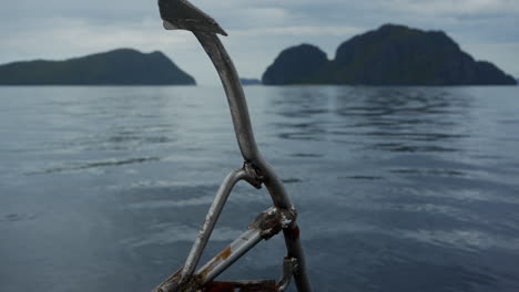 panning up from ropes on boat looking towards ocean and islands in philippines