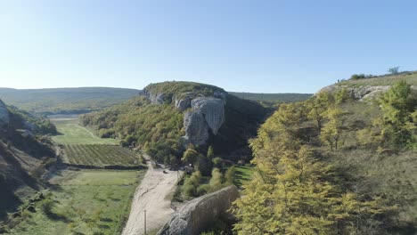 aerial view of a valley with mountains, rock formations and farmland