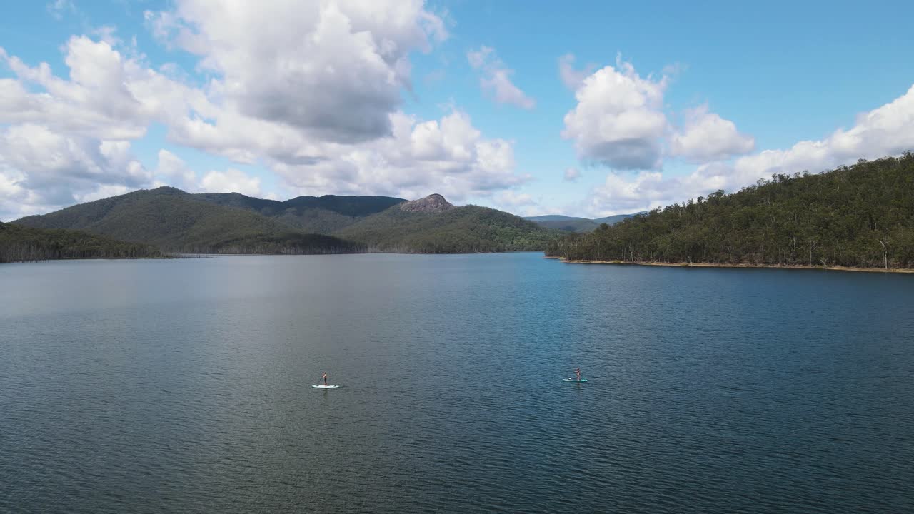 흐린 산을 배경으로 하는 큰 호수에 있는 인기 있는 수상 활동 휴양지
