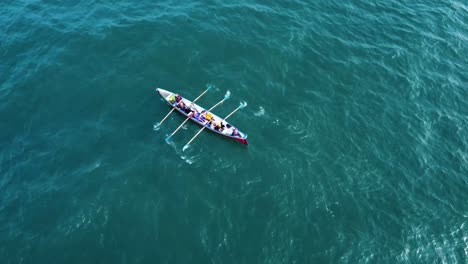 Un-Bote-De-Remos-En-Solitario,-Remando-En-El-Mar,-Frente-A-La-Costa-Del-Reino-Unido,-En-Un-Día-De-Verano,-Filmado-Con-Un-Dron-Dji-Mavic,-Que-Se-Desplaza-Hacia-Arriba-Para-Revelar-El-Horizonte